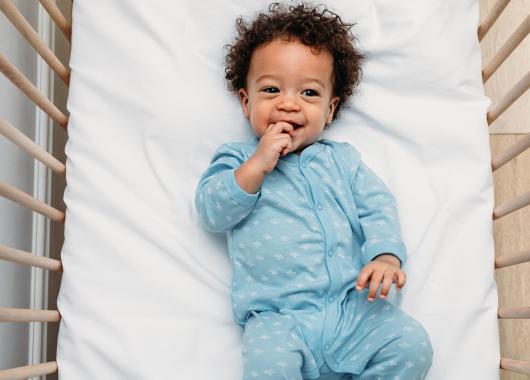 Toddler smiles in cot