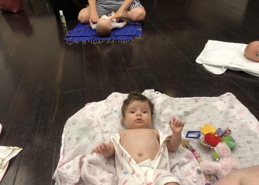 Baby on a floor mat about to be massaged 