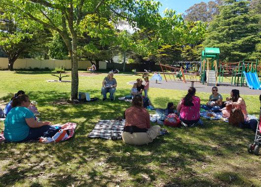 A sunny day, mums sitting in the shade of a tree