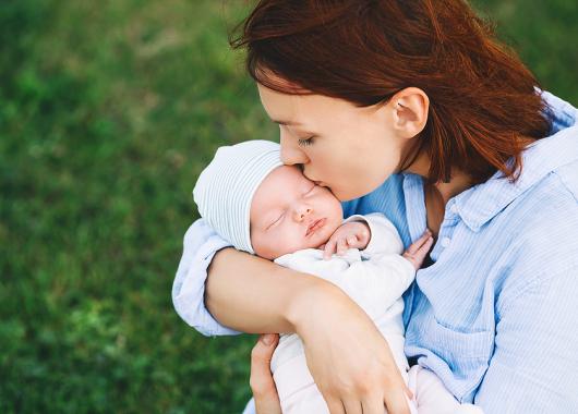 mum kissing newborn