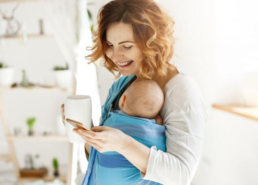 mum carrying baby holding cup