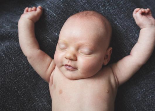 Baby sleeping and arms up in the air