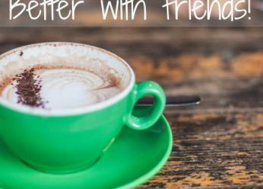 A green mug filled with coffee with the words 'Coffee Better with Friends!'