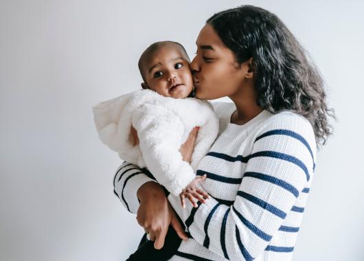 mum kissing baby on the cheek