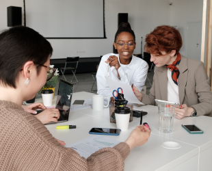 Three women sitting around table working