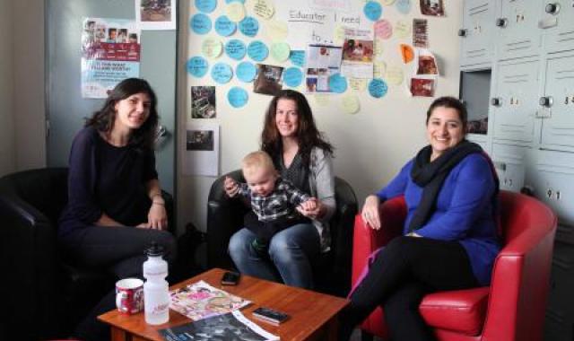 Mother and baby sitting with two female colleagues