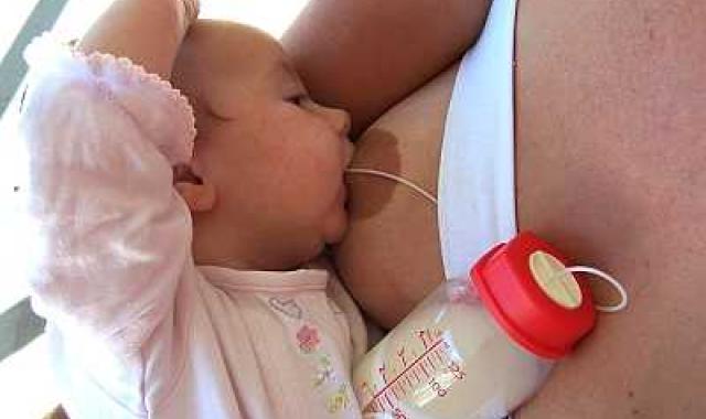 A mum and baby breastfeeding, using a supply line