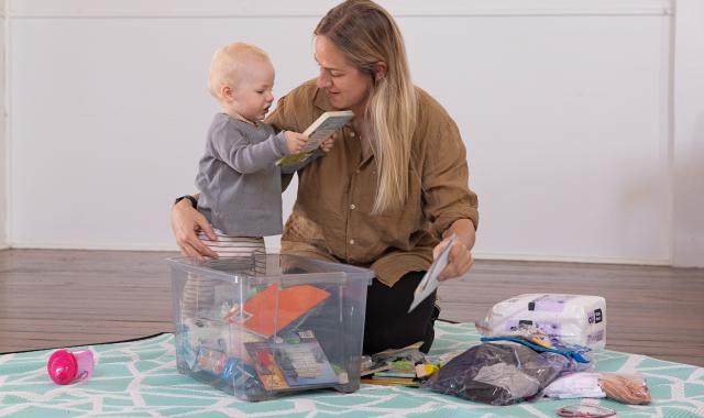 Mother and toddler packing an emergency evacuation kit together