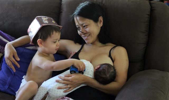 Mum feeding baby with toddler