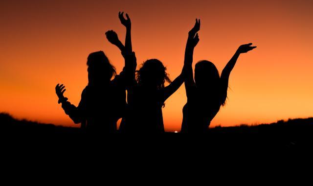 The silhouette of three women together.